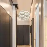 Plafonnier suspendu en origami au design moderne, suspendu dans une salle, il est en forme de pomme de pin, il se trouve dans un couloir à l'entrée d'une maison