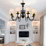 Plafonnier americain au design vintage en métal noir, en forme de chandelier avec 8 lampes en tissu dans un salon