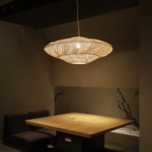 Plafonnier naturel suspendu LED de style rétro en bambou allumé dans une pièce avec une table au centre